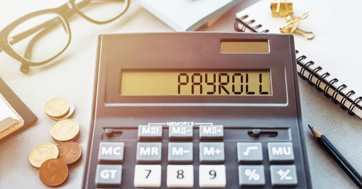 Calculator displaying the word "Payroll" surrounded by coins, glasses, and a notebook, representing payroll management and the importance of avoiding payroll errors for businesses.